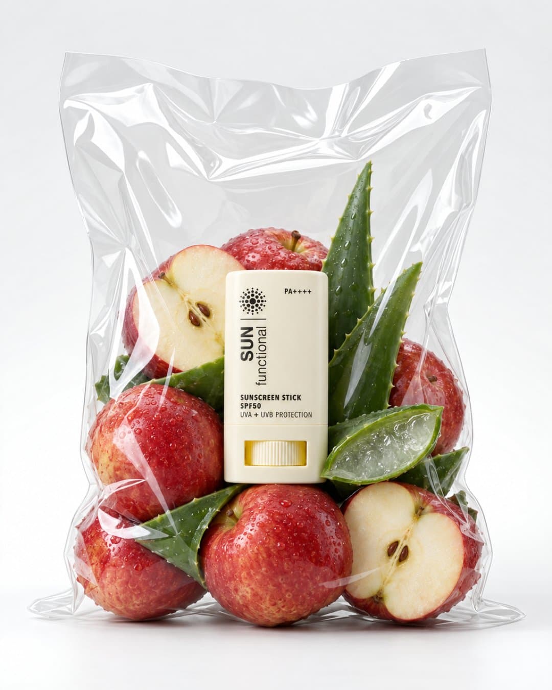 Sunscreen stick inside a clear produce bag with apples and aloe
