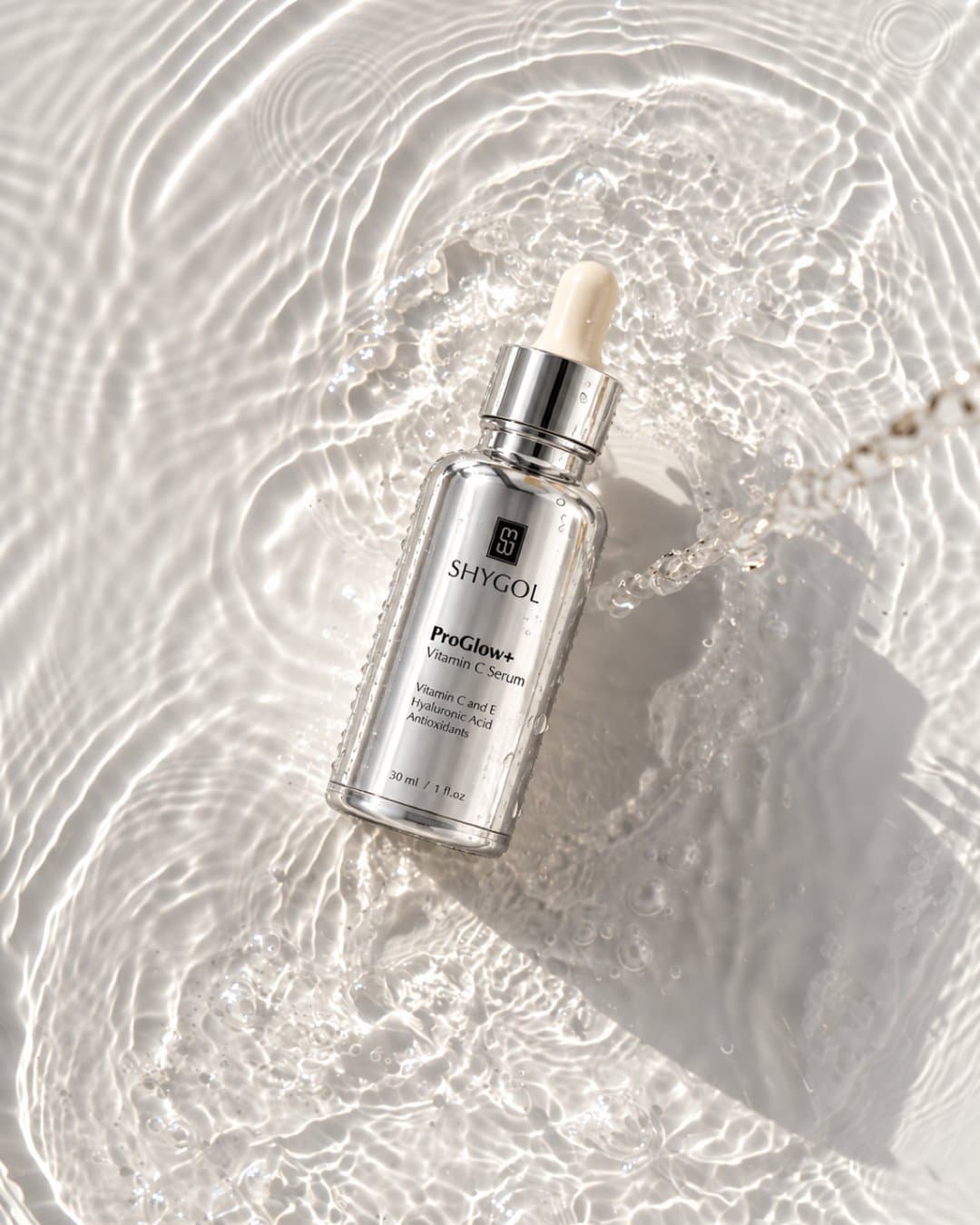 Silver serum bottle resting in rippled water with dappled sunlight