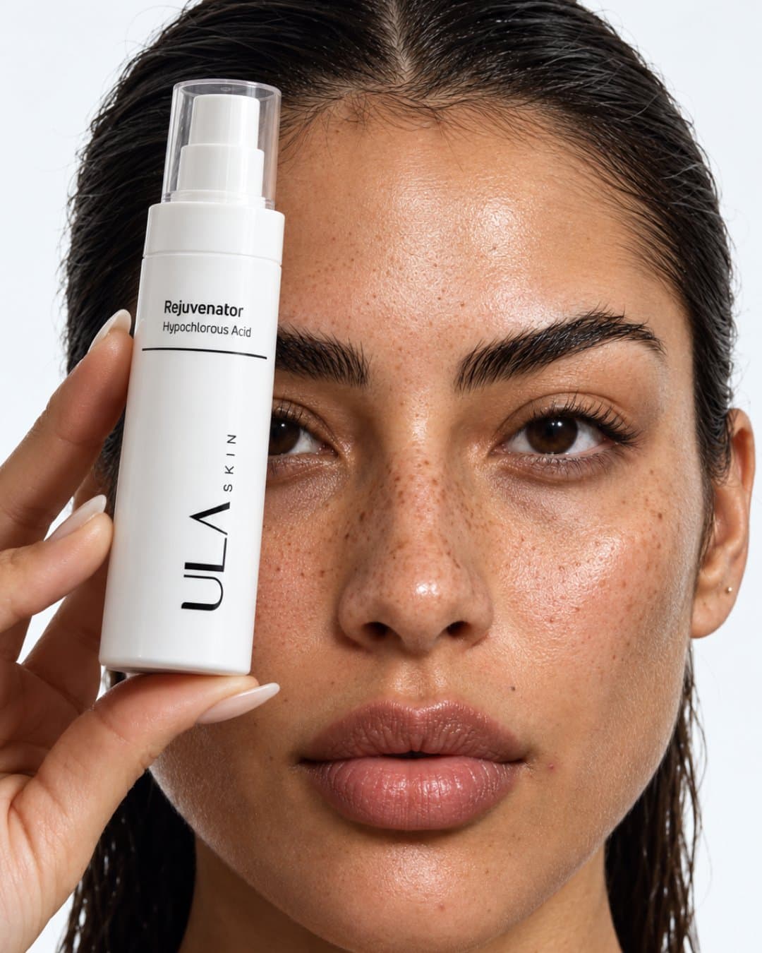 Model holding a ULA spray bottle beside her face