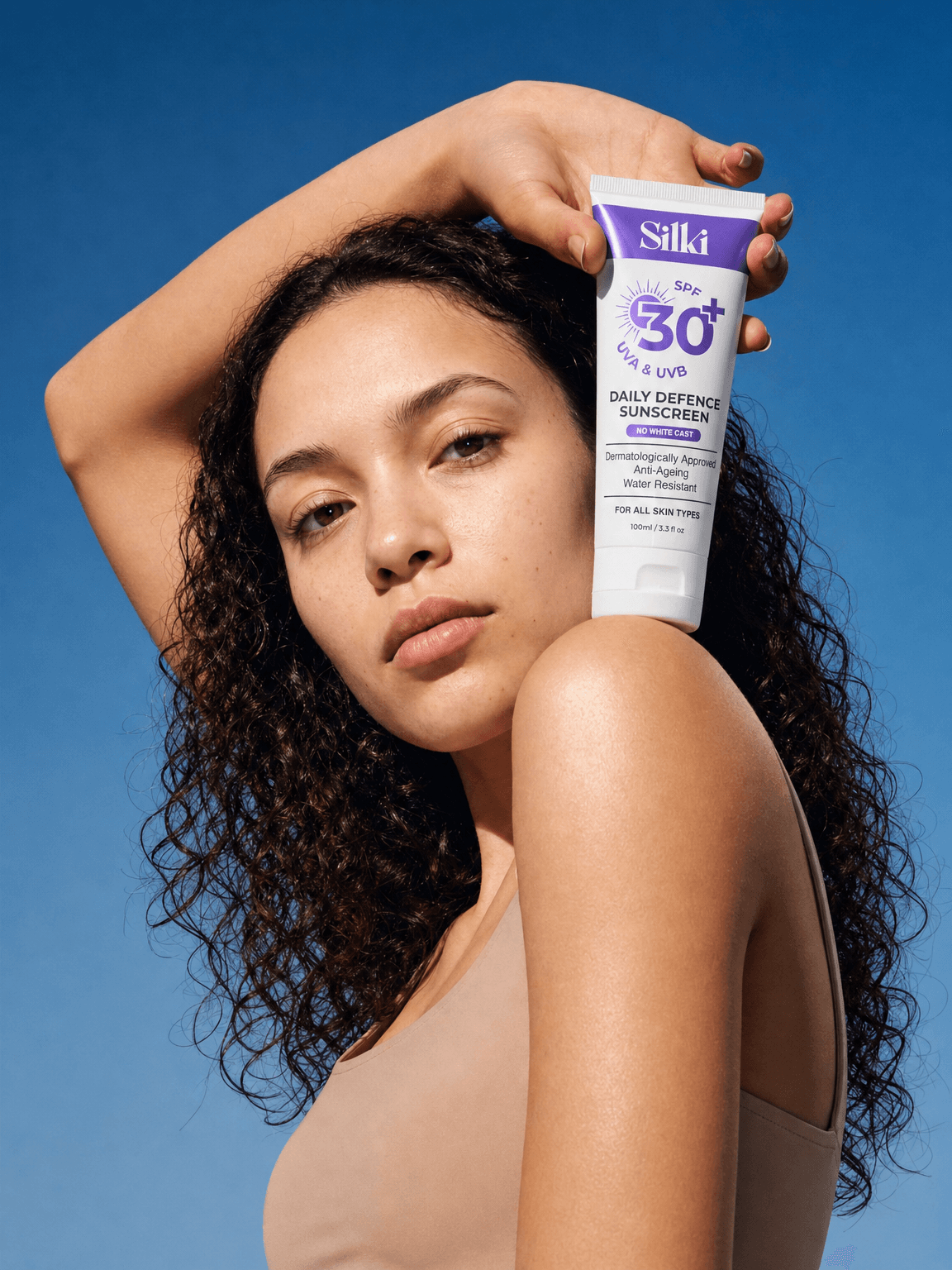 Creator holding an SPF tube against a blue sky
