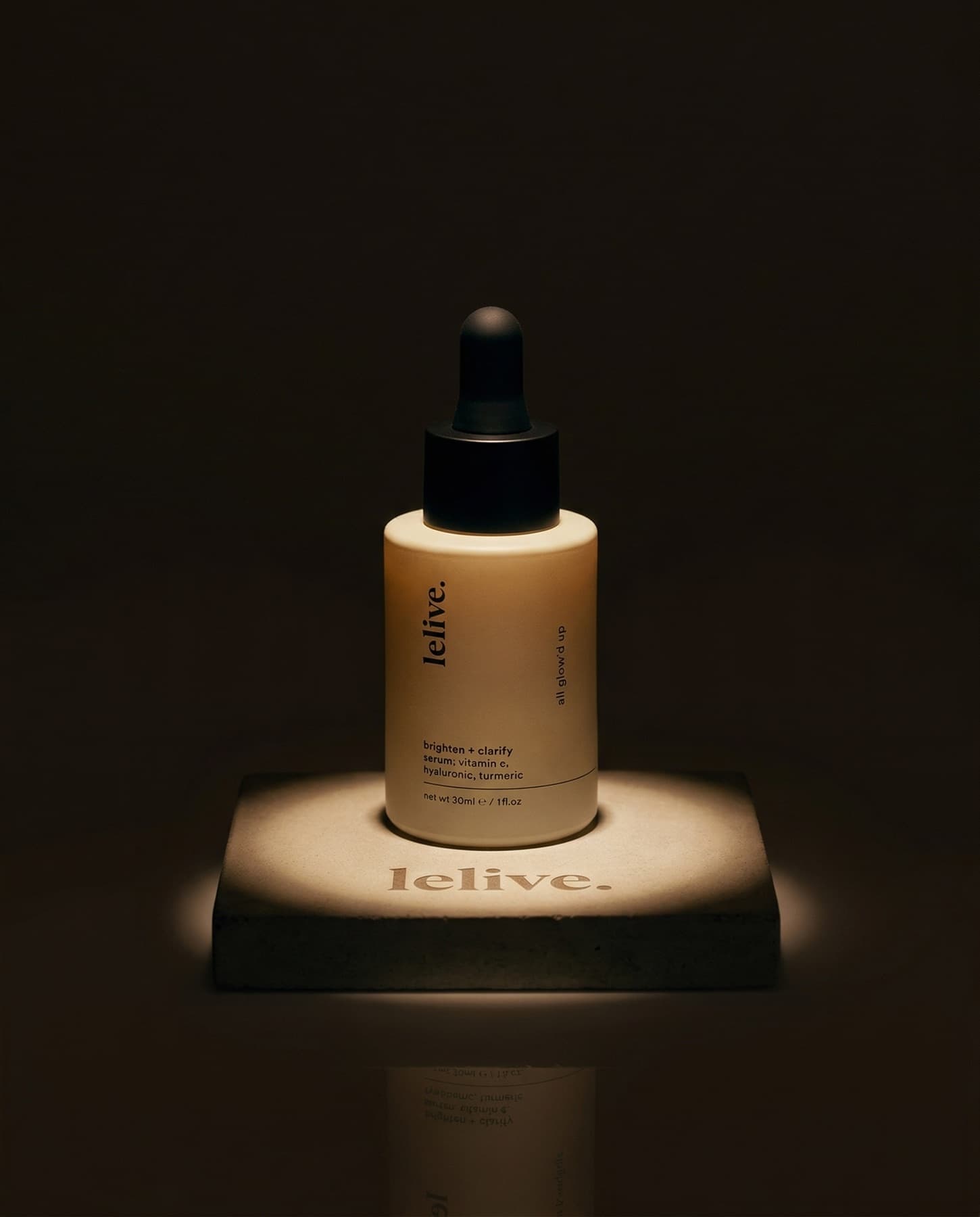Lelive serum bottle on a pedestal in a moody low-key studio